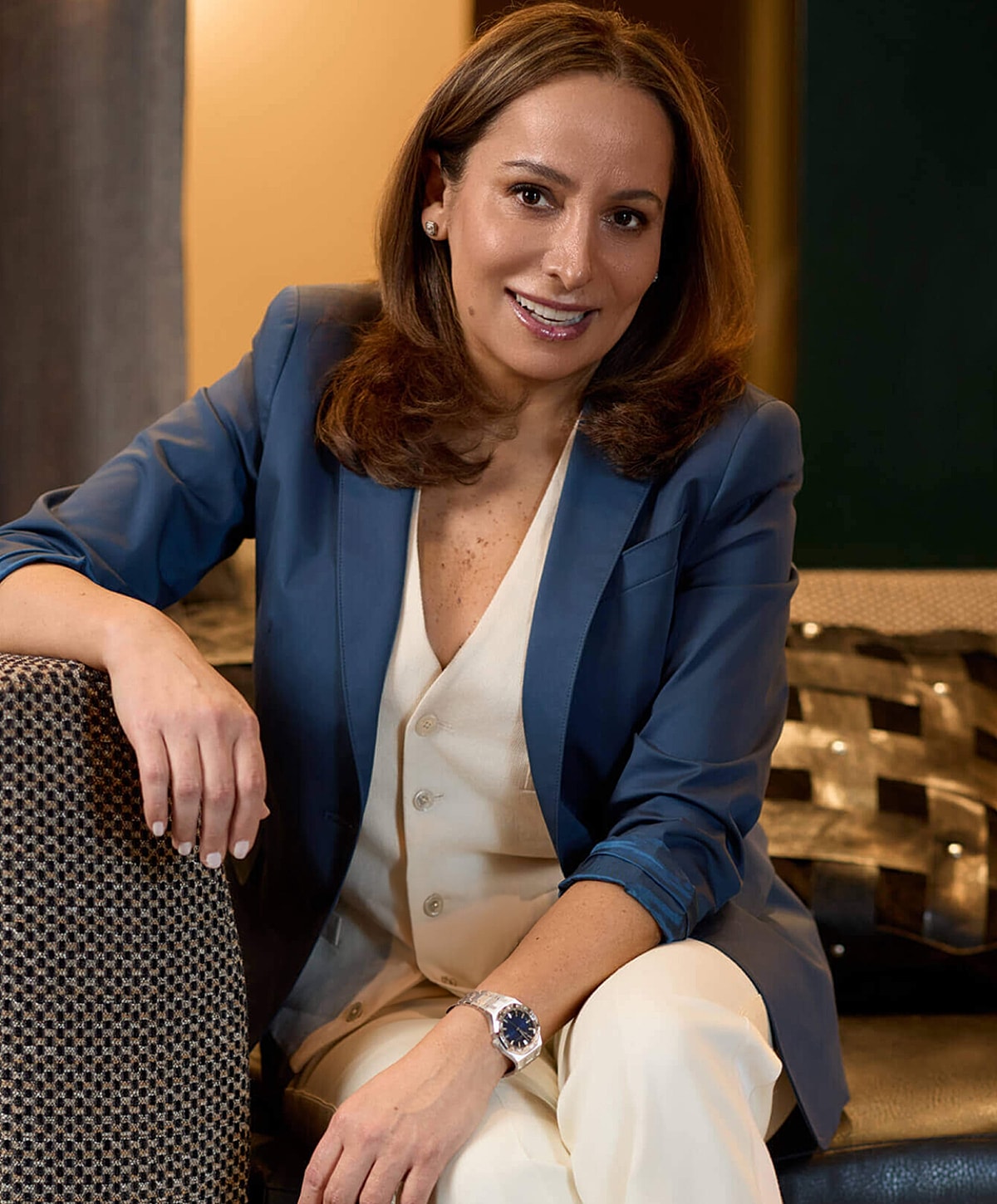 Woman in business attire sitting on a couch.