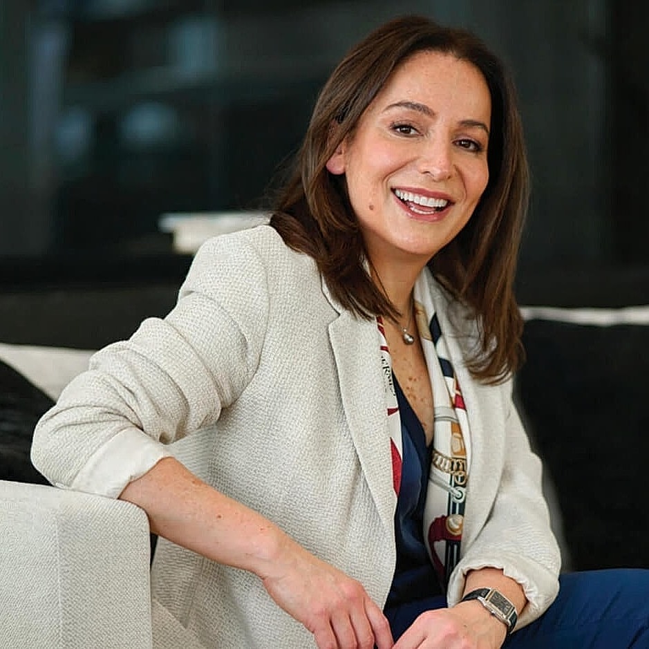 Smiling woman sitting on a couch indoors.