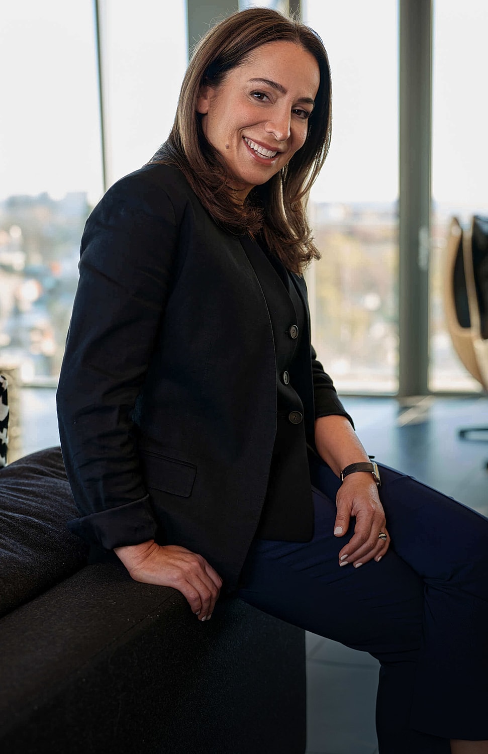Professional woman smiling in modern office setting.
